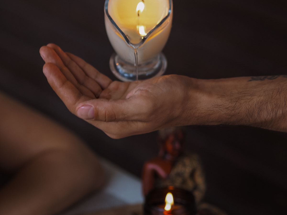 Huile de massage tiède versée à la lueur d'une bougie